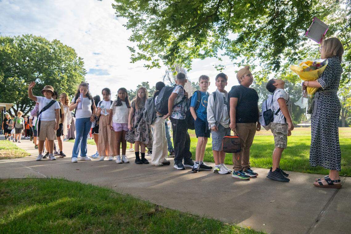 Students follow fourth-grade teacher Dominique Antennuci Neil, right, toward their classroom on the first day of school at Williamson Elementary School in Rancho Cordova on Thursday, Aug. 8, 2024.