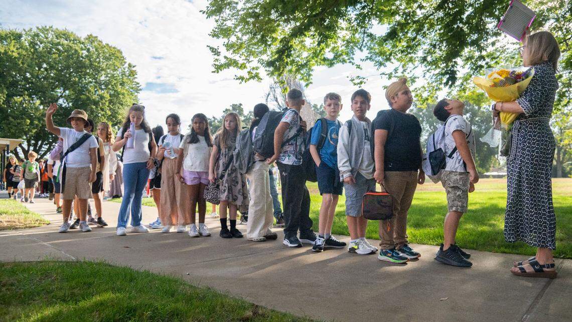 Students follow fourth-grade teacher Dominique Antennuci Neil, right, toward their classroom at Williamson Elementary School in Rancho Cordova in Aug. 2024. A new poll conducted by the Public Policy Institute of California asked adults how they felt about public education in the state.