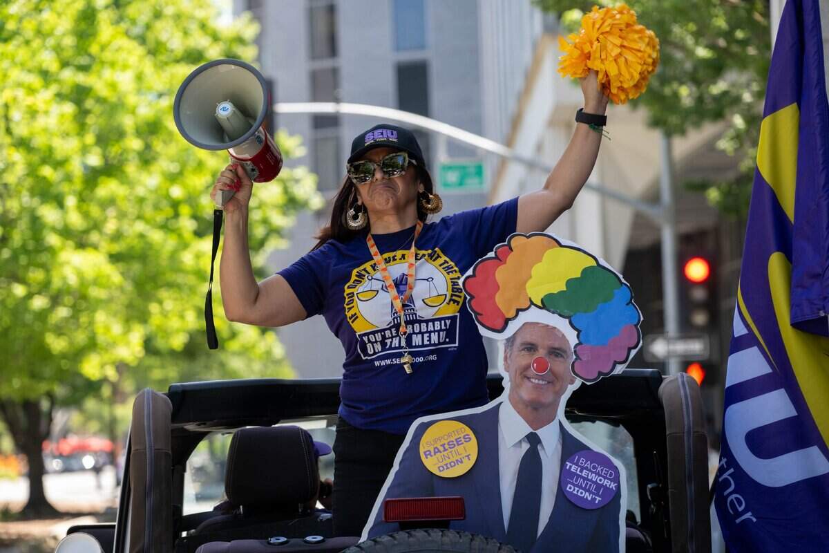 Anica Walls, president of SEIU Local 1000, leads a caravan of union members and vehicles protesting return-to-office requirements in Sacramento on Wednesday. SEIU Local 1000 members rallied to oppose state return-to-office policies affecting California government workers.