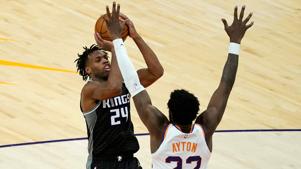 Sacramento Kings guard Buddy Hield (24) shoots over Phoenix Suns center Deandre Ayton (22) during the second half of an NBA basketball game, Thursday, April 15, 2021, in Phoenix.(AP Photo/Matt York)