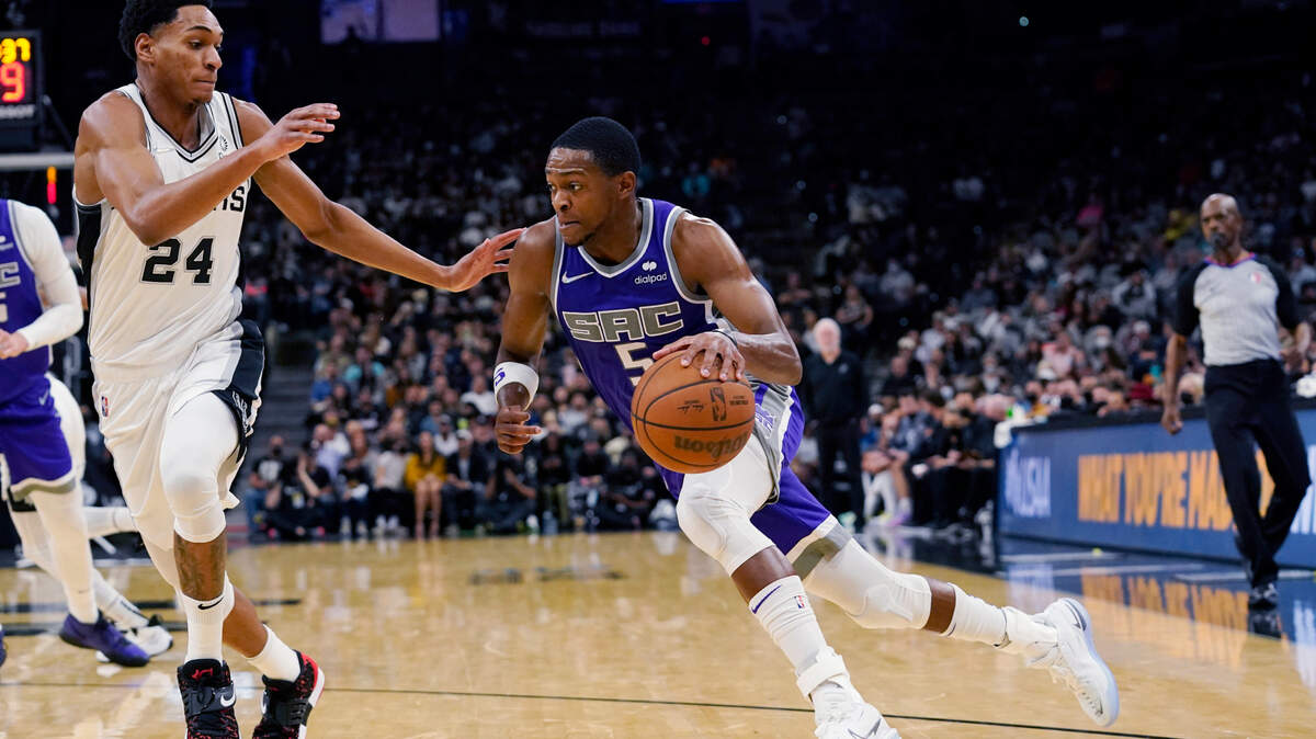 Sacramento Kings guard De’Aaron Fox (5) drives around San Antonio Spurs guard Devin Vassell (24) during the first half of an NBA basketball game Wednesday, Nov. 10, 2021, in San Antonio. (AP Photo/Eric Gay)