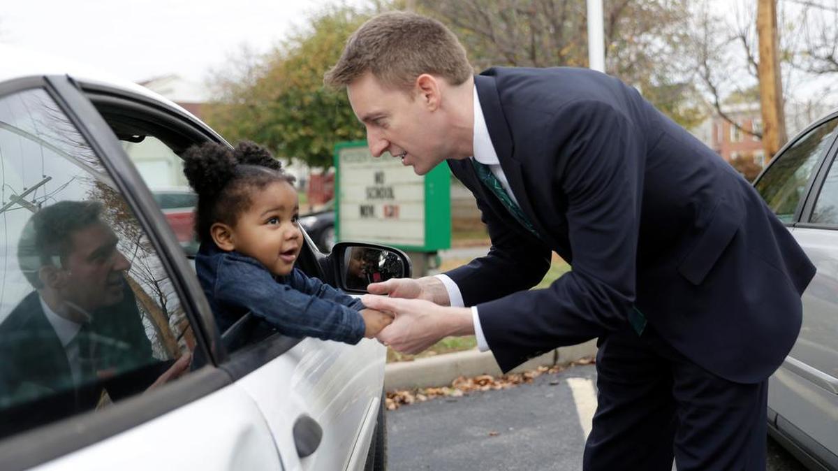 Missouri Democratic Senate candidate Jason Kander shakes hands with Teh’Riyah Hinkle, 1, as she waits in a car with her aunt as another relative votes Nov. 8 in St. Louis.