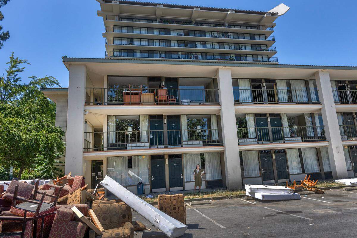 Kathy Chao Rothberg, CEO at Lao Family Community Development, looks over discarded furniture from the former Vagabond Inn in downtown Sacramento in 2023. Her organization is transforming it into campus to help transition unemployed and unhoused into permanent jobs and housing, she said.