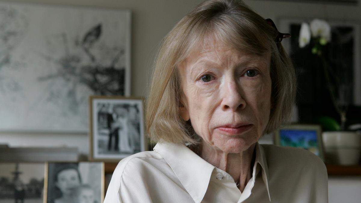 Author Joan Didion sits in front of a photo of herself holding her daughter, Quintana Roo, and another picture of her daughter’s wedding, in her New York apartment on Sept. 26, 2005. Didion, the revered author and essayist whose provocative social commentary and detached, methodical literary voice made her a uniquely clear-eyed critic of a uniquely turbulent time, has died. She was 87.