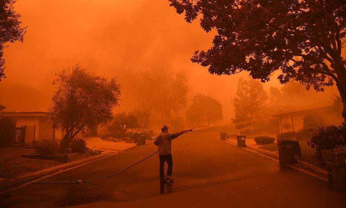 Resident David Hays sprays his neighbor’s house in Malibu as the Woolsey fire approaches on Friday, Nov. 9, 2018. (Wally Skalij/Los Angeles Times/TNS)