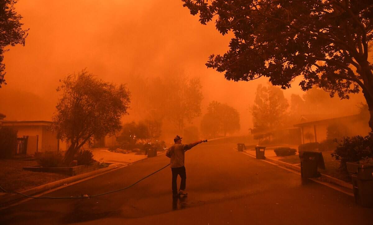Resident David Hays sprays his neighbor’s house in Malibu as the Woolsey fire approaches on Friday, Nov. 9, 2018. (Wally Skalij/Los Angeles Times/TNS)