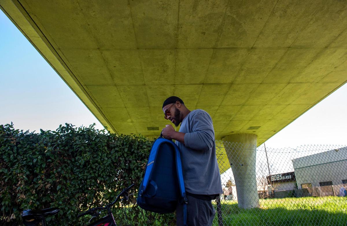Mario Joseph, 33, packs up some belongings while standing under a freeway onramp, Thursday, March 21, 2019, near a vacant lot that Sacramento City Councilmen Jay Schenirer and Steve Hansen are proposing the city open a homeless shelter.