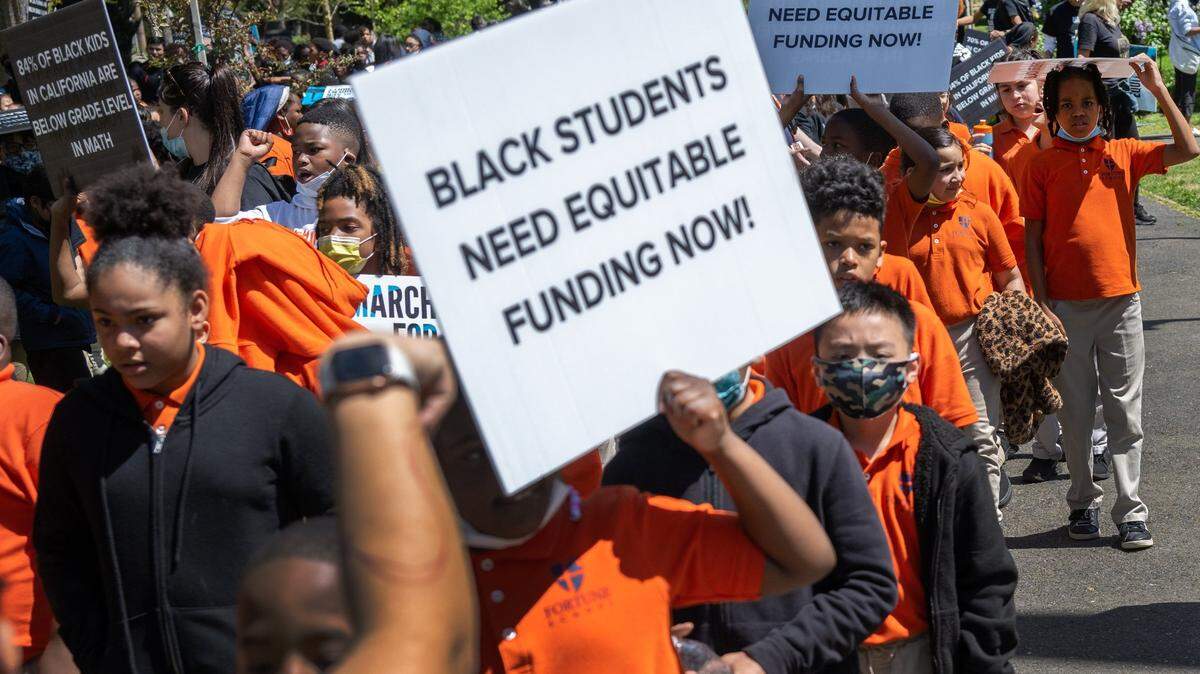 Students hold signs at a Black in School Coalition rally and march in 2023 at Capitol Park in Sacramento in opposition to Gov. Gavin Newsom’s education budget proposal, which they said doesn’t provide enough funding to narrow the academic achievement gap for Black students.