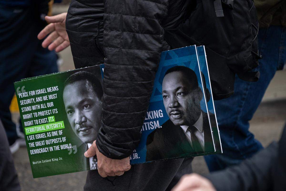 Marchers carry posters of the Rev. Martin Luther King Jr. during the Martin Luther King Jr. “Walk With Me” event at Sacramento City College on Monday.