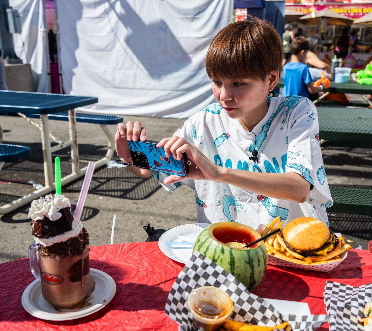 Kako Ono takes a picture of the Dark Knight milkshake from Fabe’s Churros and Gelato at the California State Fair on Friday.