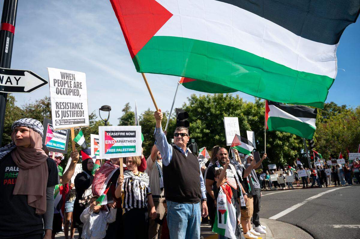 People stand on all four corners of the intersection of 16th and J streets for a rally hosted by the Sacramento Regional Coalition for Palestinian Rights on Saturday.