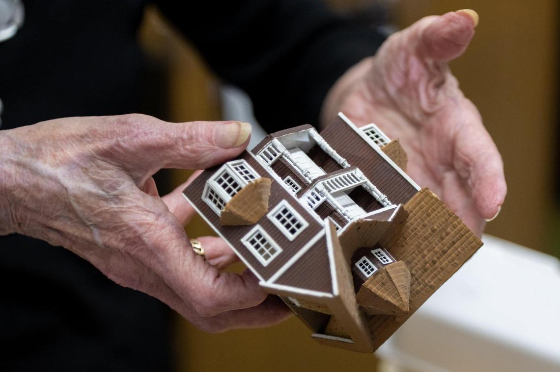 Barbara Taplin, 90, holds a miniature dollhouse Thursday, Aug. 25, 2022, that will be placed inside another dollhouse. Taplin has owned The Elegant Dollhouse for over 40 years.