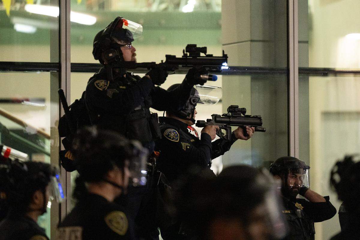 UC Berkeley police point less lethal launchers at protesters before a Turning Point USA tour event on campus on Monday, Nov. 10, 2025. 