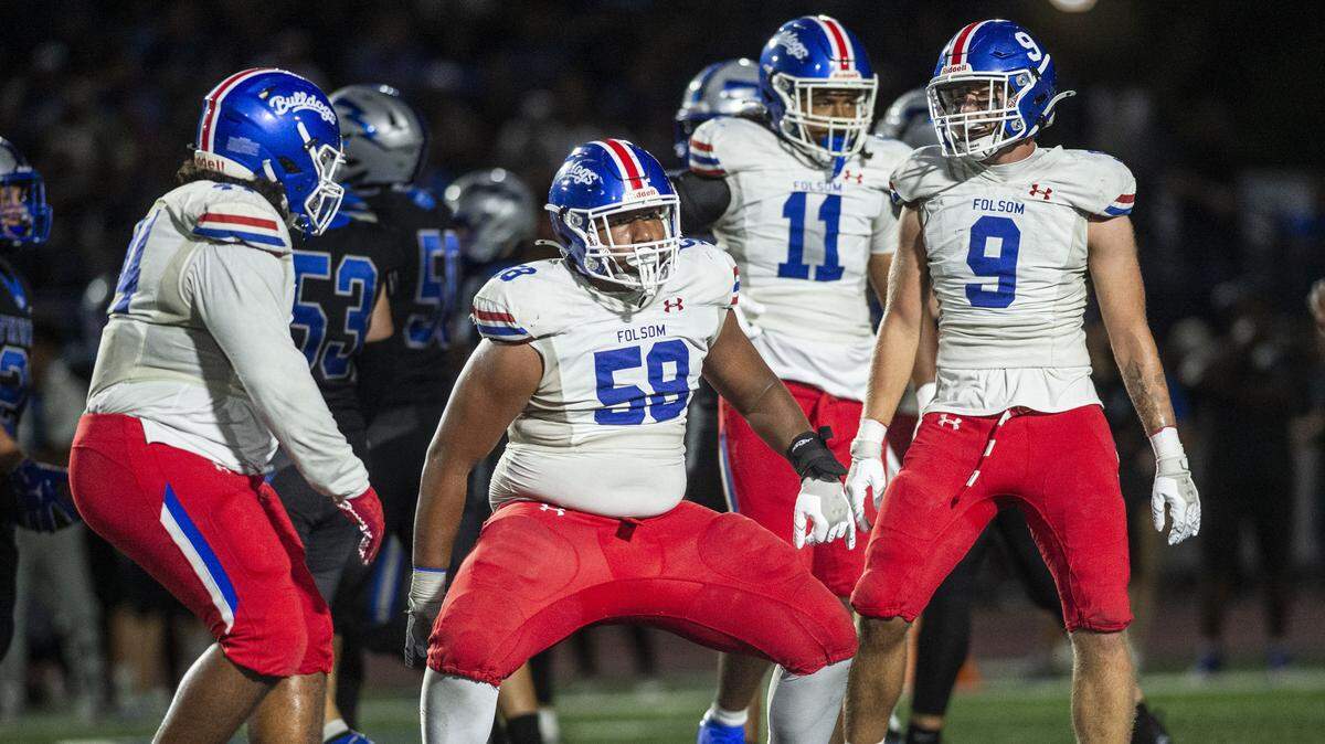 Folsom High School defender Lua Deberry (58) celebrates a sack with teammates during a high school football game against Rocklin High School on Friday in Rocklin.