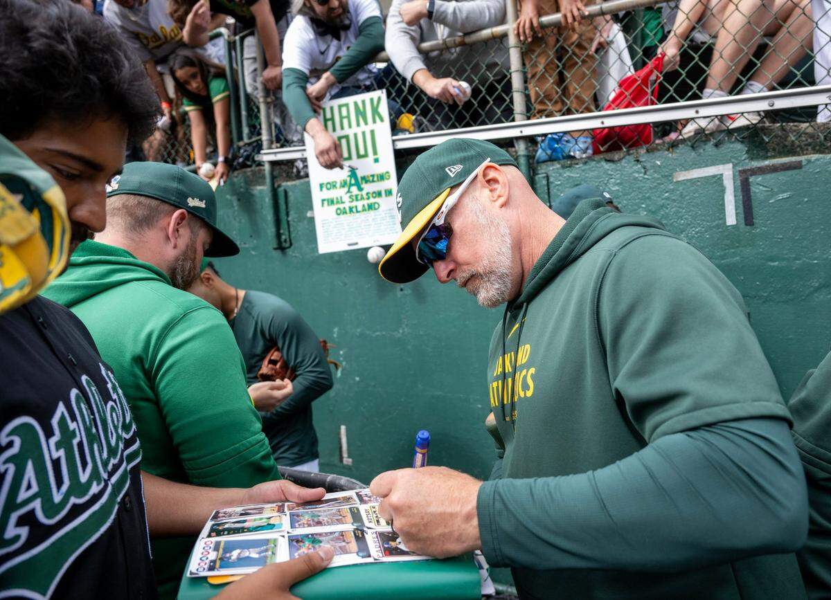Oakland A’s manager Mark Kotsay signs autographs before the team’s final game at Oakland Coliseum on Thursday. In 2025, the Oakland A’s will play in West Sacramento.