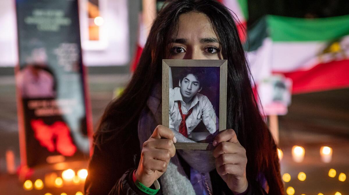 Mahi Mokhtari said she was 12 years old when her brother, Mohammad Mokhtari, was killed by the Iranian regime in 2011 as protests were happening in Tehran. She holds a photo of her brother outside the California Capitol in Sacramento on Wednesday, Dec. 14, 2022, at a gathering calling for help to end the executions of citizens protesting in Iran.