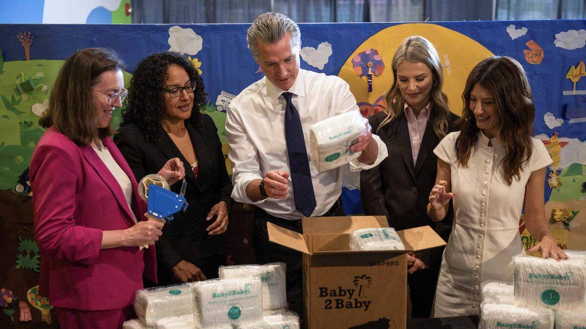 Gov. Gavin Newsom packs diapers into a box with Baby2Baby leaders after a press conference in San Francisco on Friday.