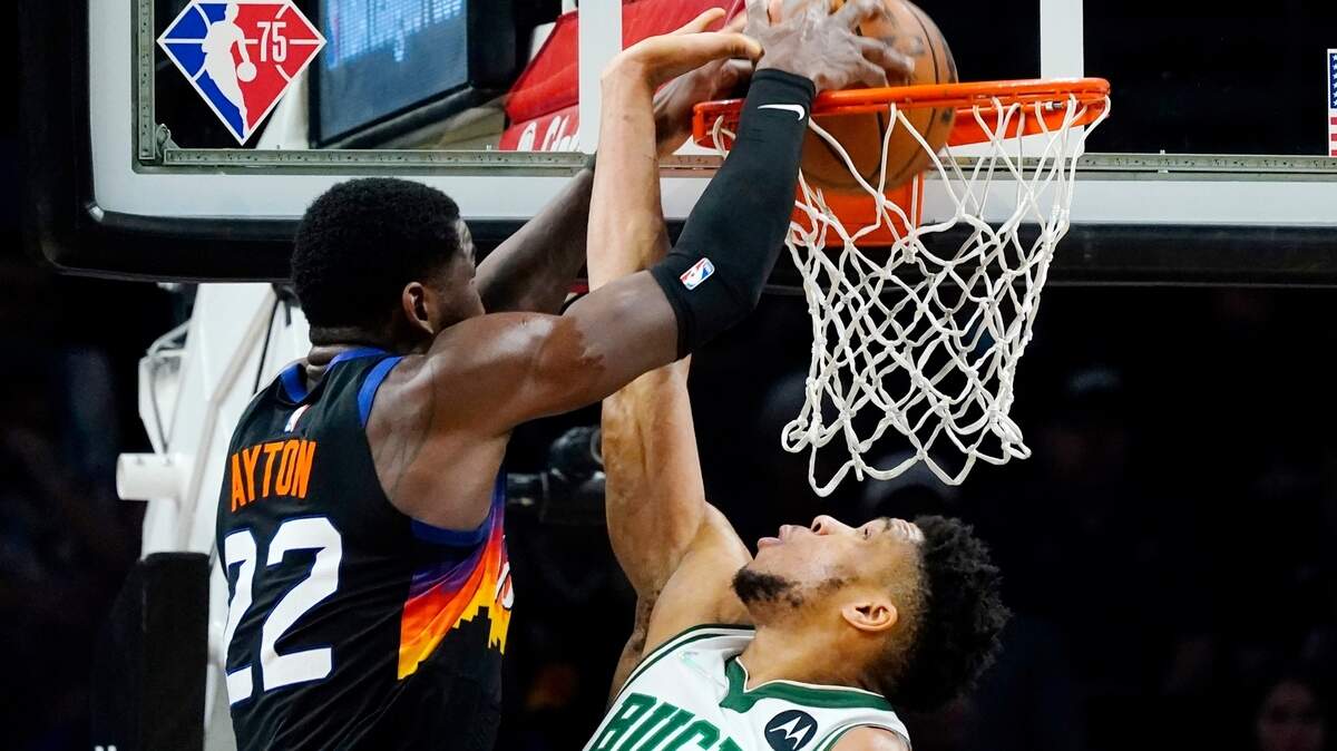 Phoenix Suns center Deandre Ayton (22) dunks against Milwaukee Bucks forward Giannis Antetokounmpo during the second half of an NBA basketball game Thursday, Feb. 10, 2022, in Phoenix. The Suns won 131-107. (AP Photo/Ross D. Franklin)