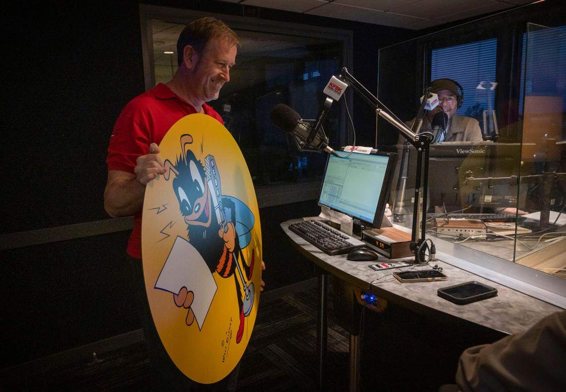 Former Newsradio KFBK anchor Steve Telliano holds a photo of “Gaby,” a mascot drawn for KFBK by Walt Disney to complement The Sacramento Bee’s Scoopy, that is now housed at the Center for Sacramento History, during a special 100-year anniversary broadcast on KFBK’s The Pat Walsh Show on Friday, Sept. 16, 2022.