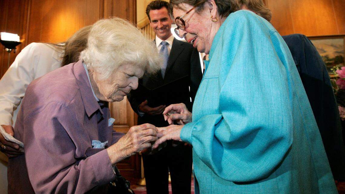 Del Martin, left, places a ring on her partner Phyllis Lyon, right, in this June 16, 2008 file photo during their wedding ceremony officiated by then San Francisco Mayor Gavin Newsom, center, at City Hall in San Francisco. Newsom as governor with California First Partner Jennifer Siebel Newsom inducted the couple, pioneers in campaigns for marriage equality, into the California Hall of Fame on Oct. 12, 2021.