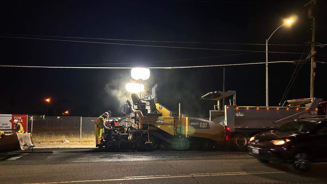 A construction crew works to repave part of Martin Luther King Jr. Boulevard as cars pass close by. Family members often worry about the danger of working just feet from fast-moving traffic.