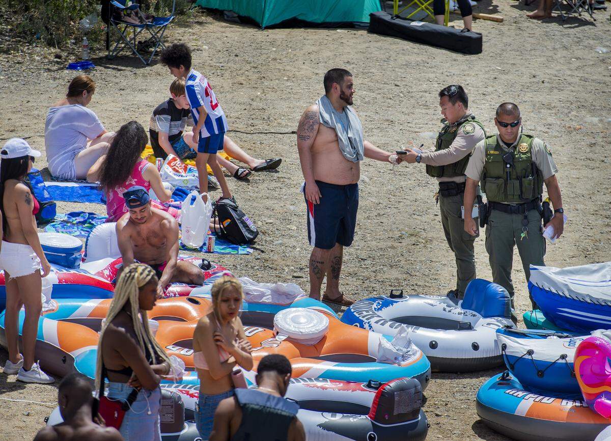 A Sacramento County park ranger issues an alcohol citation to an American River visitor in the Sunrise Recreation Area near Rancho Cordova on Sunday. Alcohol is banned along the shoreline of the American River between Hazel and Watt avenues on Memorial Day weekend, the 4th of July and Labor Day weekend.