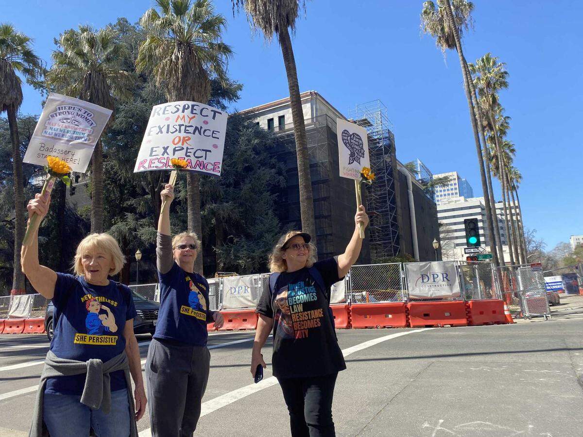 Beverly Mapps, left, and her daughters, Melanie Mapps, center, and Tracy Wilson, right, on Saturday March 8, 2025, participate in an International Women’s Day demonstration at the corner of L and 10th streets in downtown Sacramento.