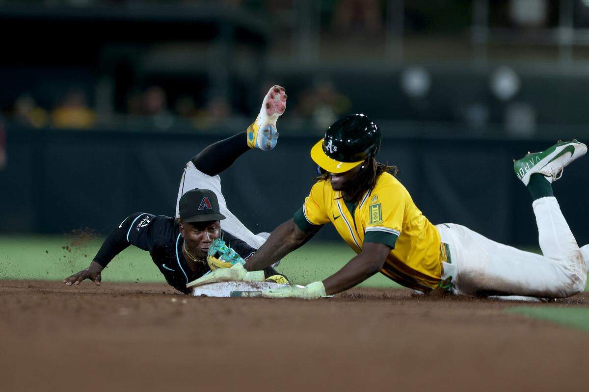 Arizona Diamondbacks shortstop Geraldo Perdomo dives toward second base ahead of Athletics center fielder Lawrence Butler for a force out during the fifth inning Saturday at Sutter Health Park in West Sacramento.