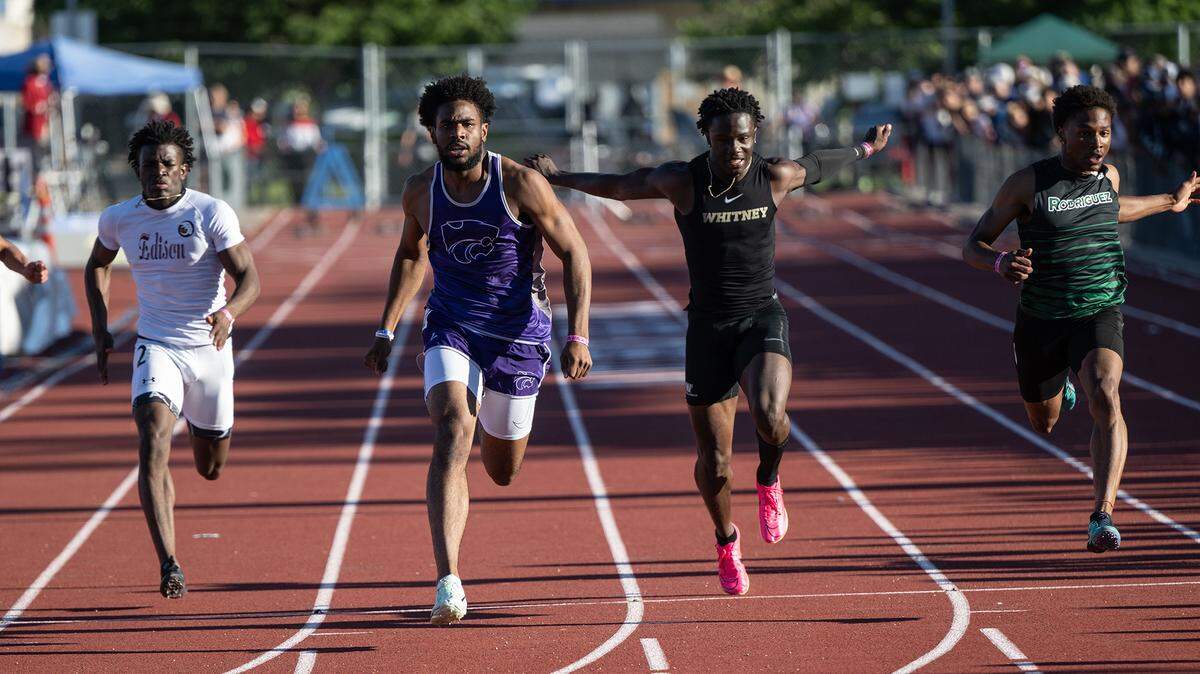 Ian Dossman of Franklin-Elk Grove, second from left, wins the 100 meter race ahead of Xavier Bruce of Whitney, right, in the CIF Sac-Joaquin Section Masters track finals at Davis High School on Saturday.