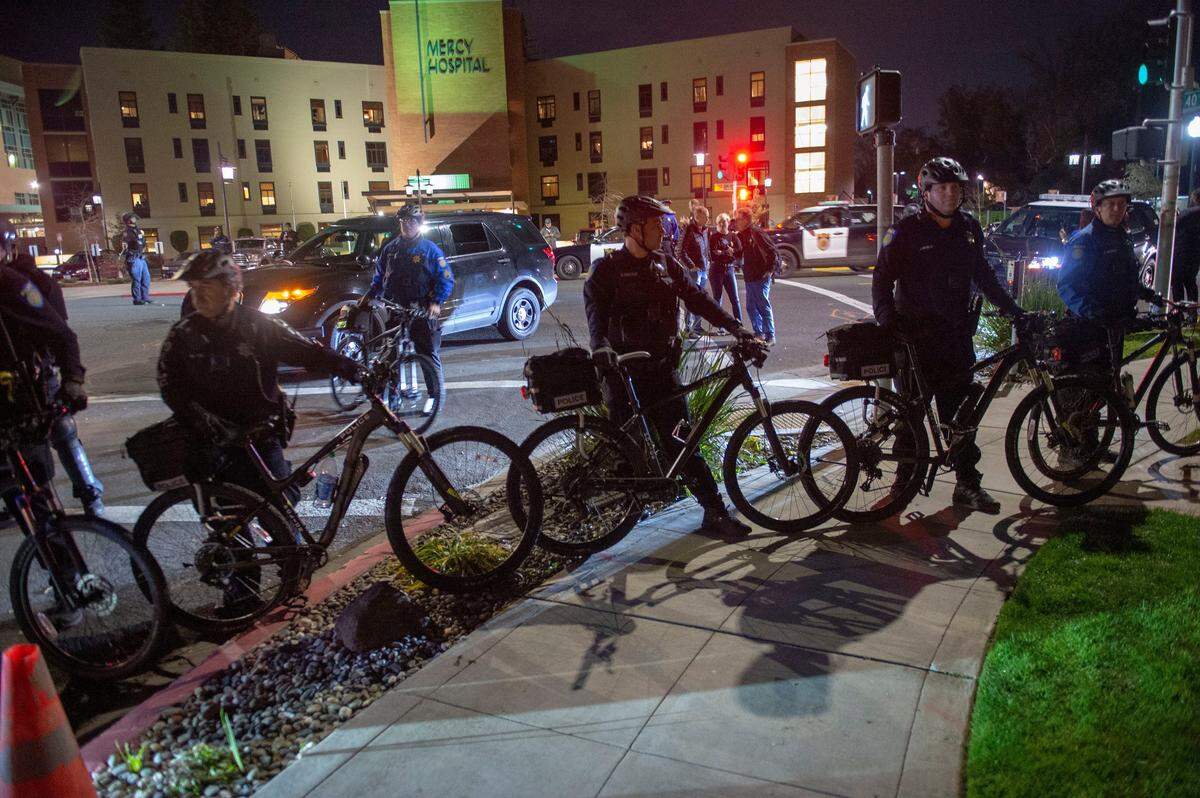 Sacramento bicycle police cordon off an area near Mercy Hospital in East Sacramento after a heated incident between a man in a MAGA hat and the protestors at a Stephon Clark protest in East Sacramento on Monday. In the background, Bee reporter Sam Stanton interviews Tahoe Park resident Dan Iverson, who wore the hat.