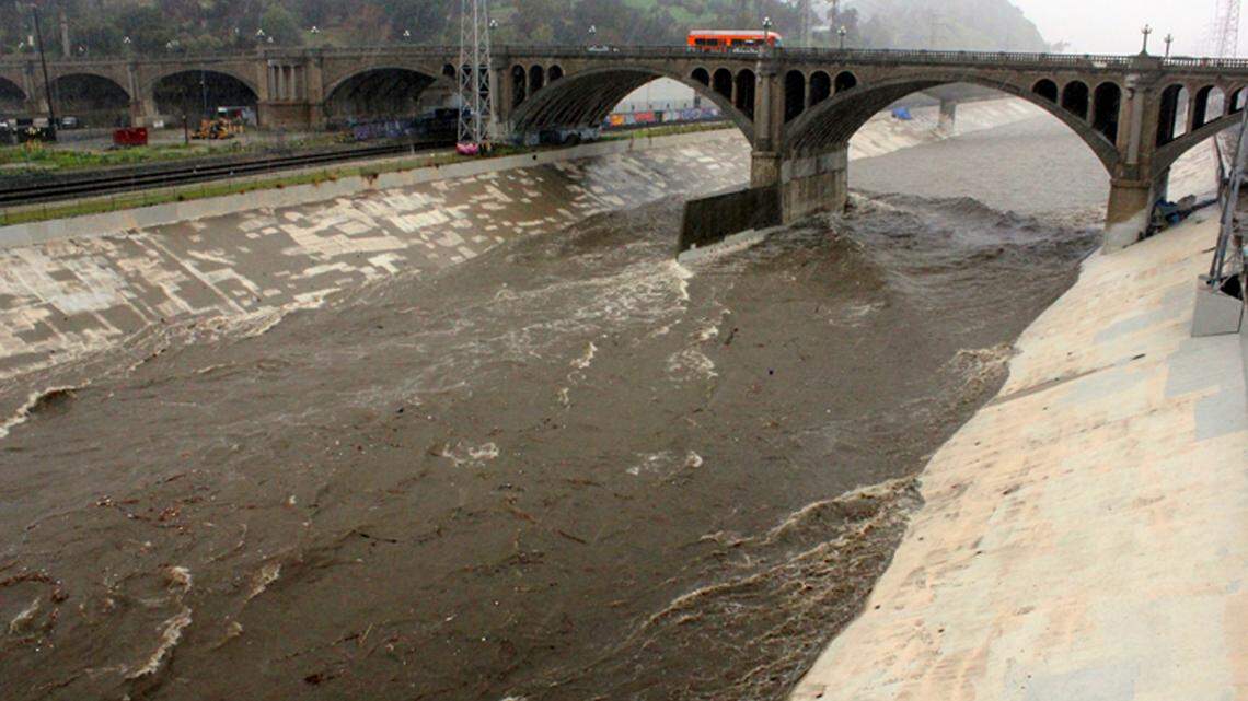 Wwater races down the concrete-lined channel of the swollen Los Angeles River, under the North Broadway Bridge near downtown Los Angeles, in 2019. On Tuesday, firefighters rescued a man who had been swept into an underground channel of the river.