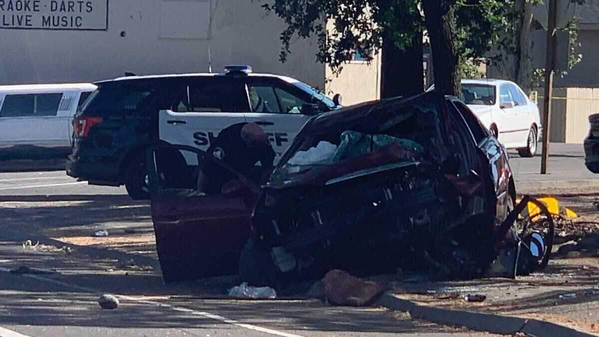 A Sacramento County sheriff’s deputy looks into a vehicle that crashed into a tree Thursday in Arden Arcade. Three people in the vehicle have been taken to a hospital.