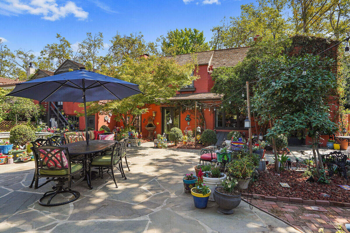 A deep backyard designed for entertaining includes a studio and a pool.