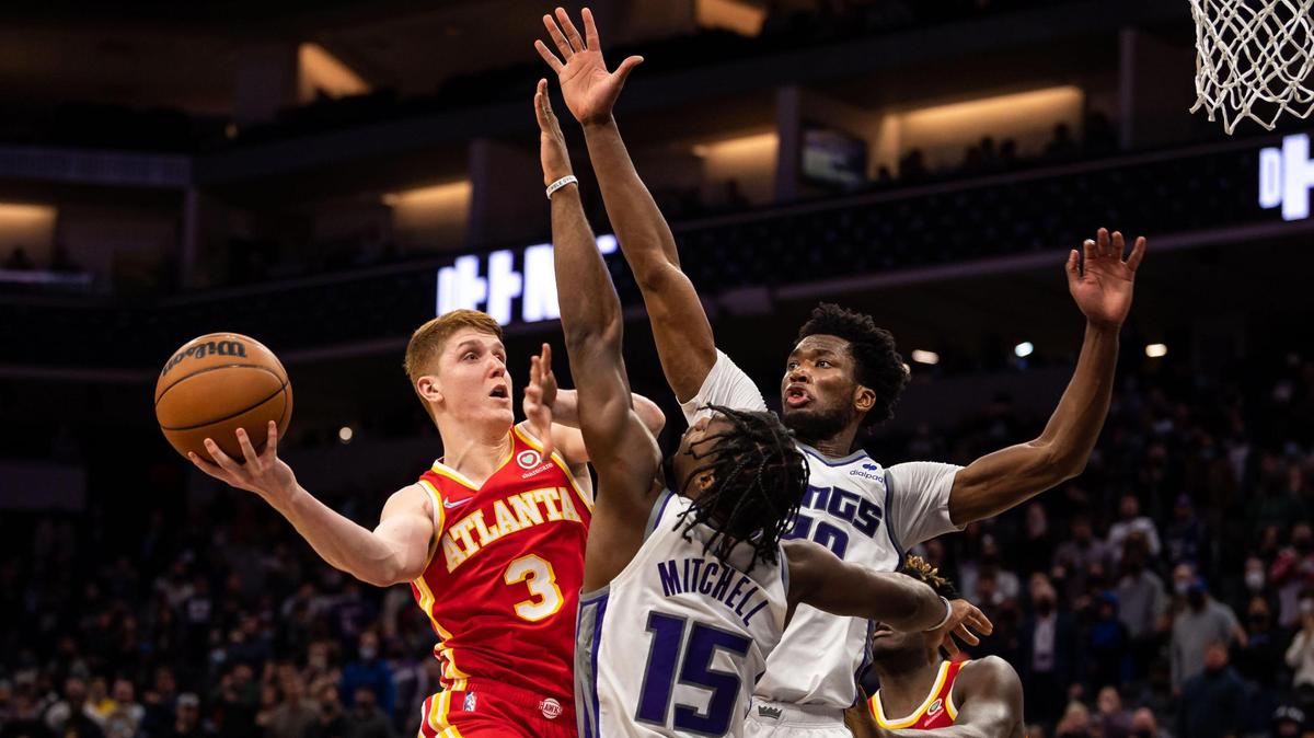 Atlanta Hawks guard Kevin Huerter (3), left, goes up for two points against Sacramento Kings guard Davion Mitchell (15), center, and center Damian Jones (30) during the fourth period of the Hawks’ win at the NBA basketball game Wednesday, Jan. 5, 2022, at Golden 1 Center in Sacramento.