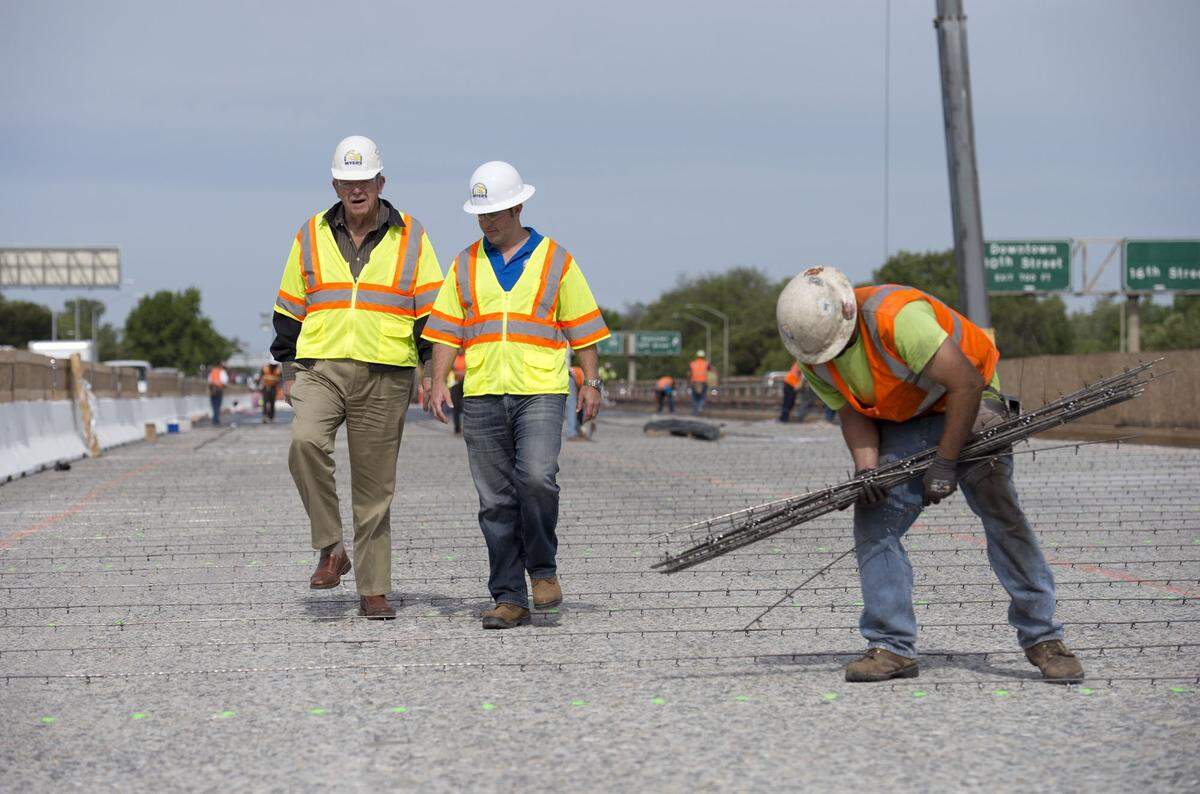 C.C. Myers, left, and his son Clint walk on the W-X segment of Highway 50 as construction crews prepare to repave the surface in 2014. 