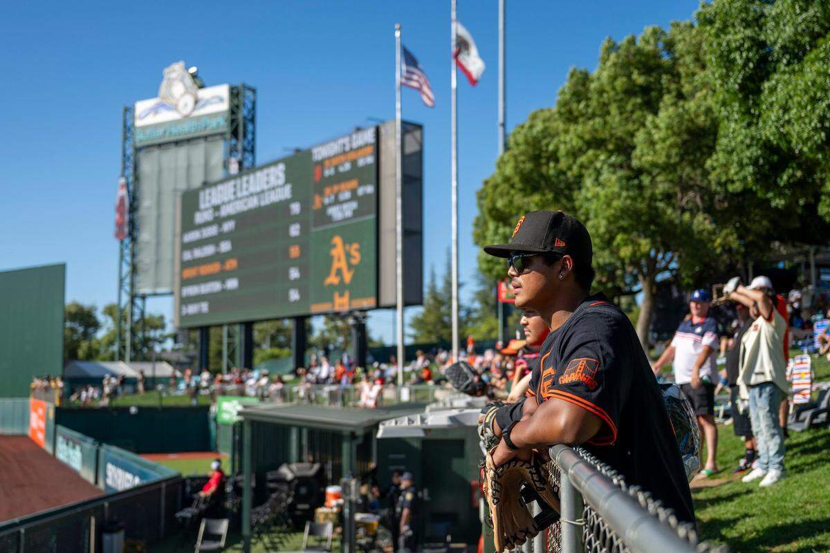 Maximus Montilla leans on the right field fence before the San Francisco Giants first game against the Athletics at Sutter Health Park on Friday, July 4.
