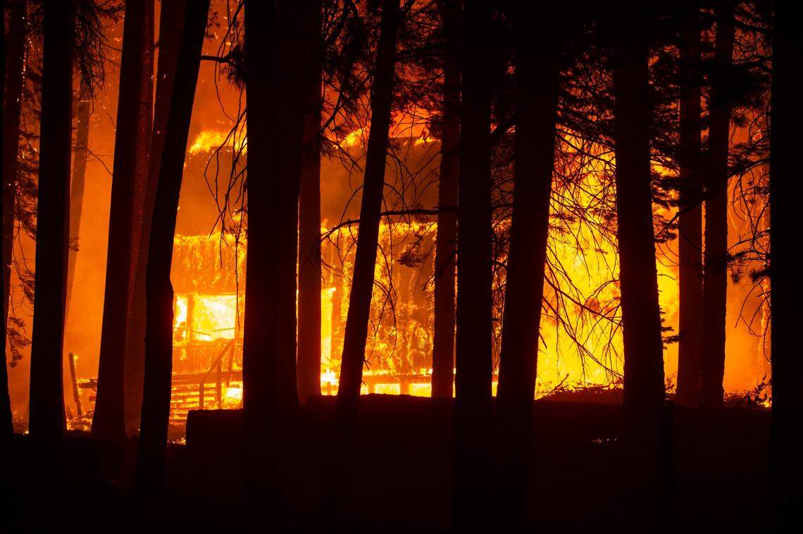 A cabin near the Aspen Creek Tract is engulfed in flames along Highway 50 east of Twin Bridges on Sunday evening. A several homes were destroyed in the area.