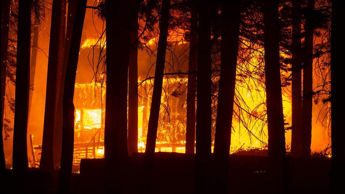 A cabin near the Aspen Creek Tract is engulfed in flames along Highway 50 east of Twin Bridges on Sunday evening, Aug. 29, 2021. 