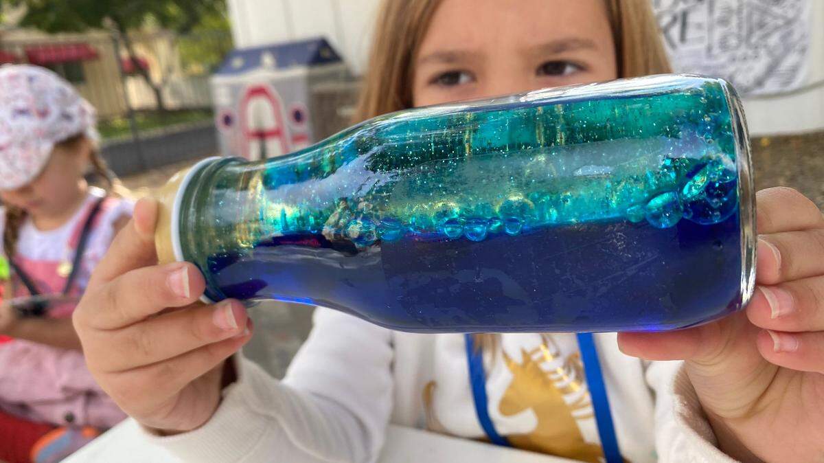 Sophia Lofthouse holds an ocean in a bottle during a Wild Roots science class.