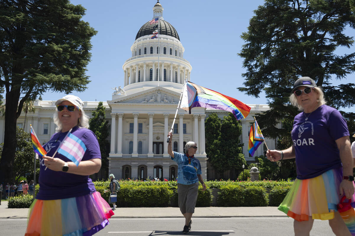 Nancy McKernan, center, waves a pride flag in front of the California Capitol during the Sacramento Pride Parade in Sacramento on Sunday, June 14, 2026.