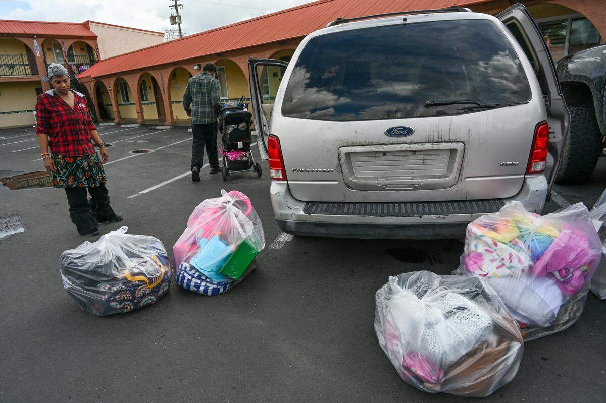 Tanika Williams, 38, gets ready to load her family’s belongings that The Greens Hotel workers had bagged up and locked inside their room on Feb. 15. After the family was escorted off the grounds by police the night before they were given a voucher for a night in a Motel 6. They returned the following morning to retrieve their things.