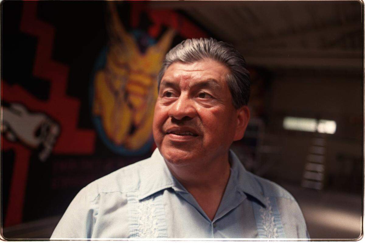 Sacramento artist Esteban Villa stands in front of the Washington Neighborhood Center mural during restoration work in 1997.