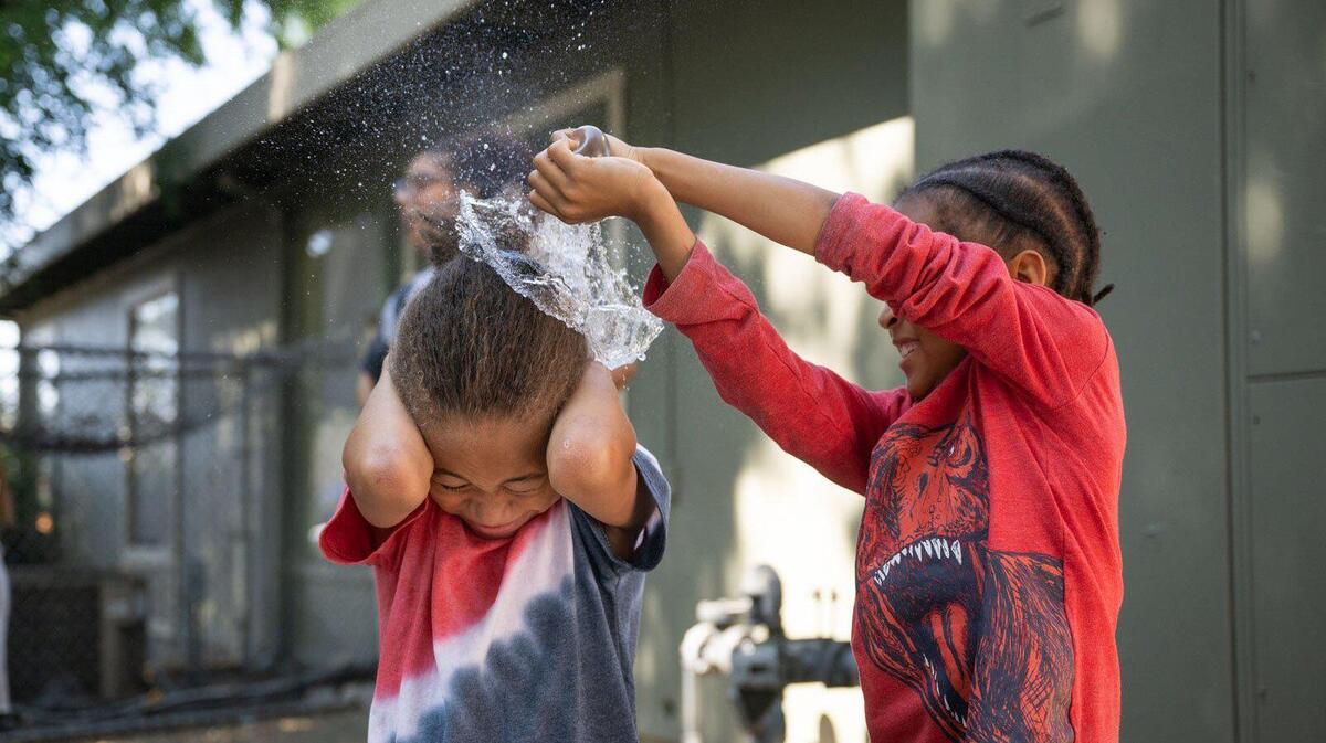 Kids who participate in a neighborhood youth program in North Sacramento, called The GreenHouse, play with water balloons during social time Monday, July 3, 2023. Participants and families say the program empowers young people on the block.
