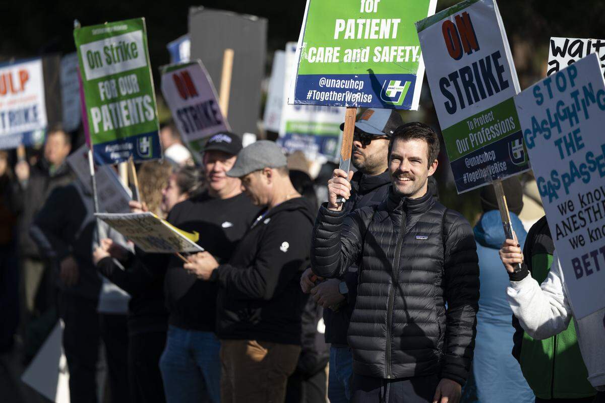 Striking medical workers wave signs outside Kaiser Permanente’s Roseville Medical Center in Roseville on Monday, Jan. 26, 2026.