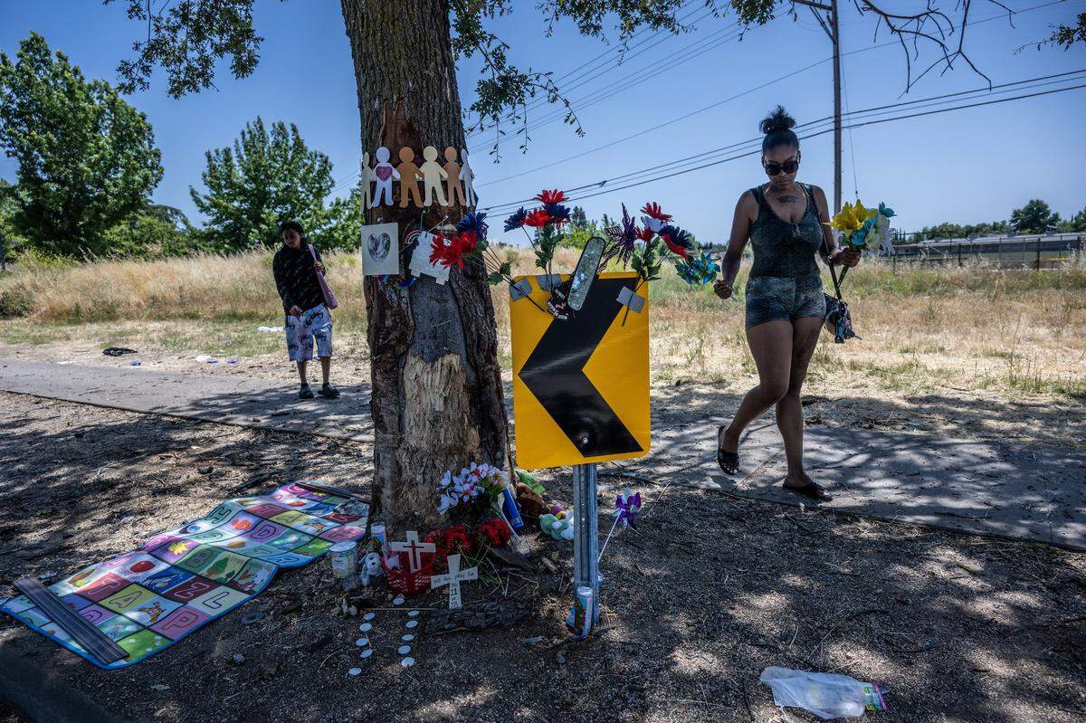 Skye Massengale brings flowers Thursday, June 1, 2023, to the scene of a crash on San Juan Road the night before where three people died and eight were injured. A short, reflective yellow sign with an arrow is all that warns oncoming traffic of the sudden curve in the street. “I felt it was right to come out here because I have a small child myself, I really feel for the young children and the mother that passed away here,” she said.