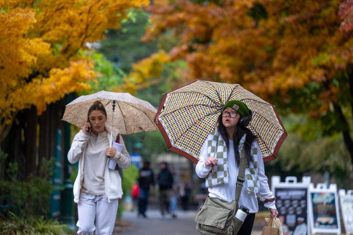 Sacramento State student Jessica Fong, right, walks through the rain on the campus on Nov. 21, 2024.