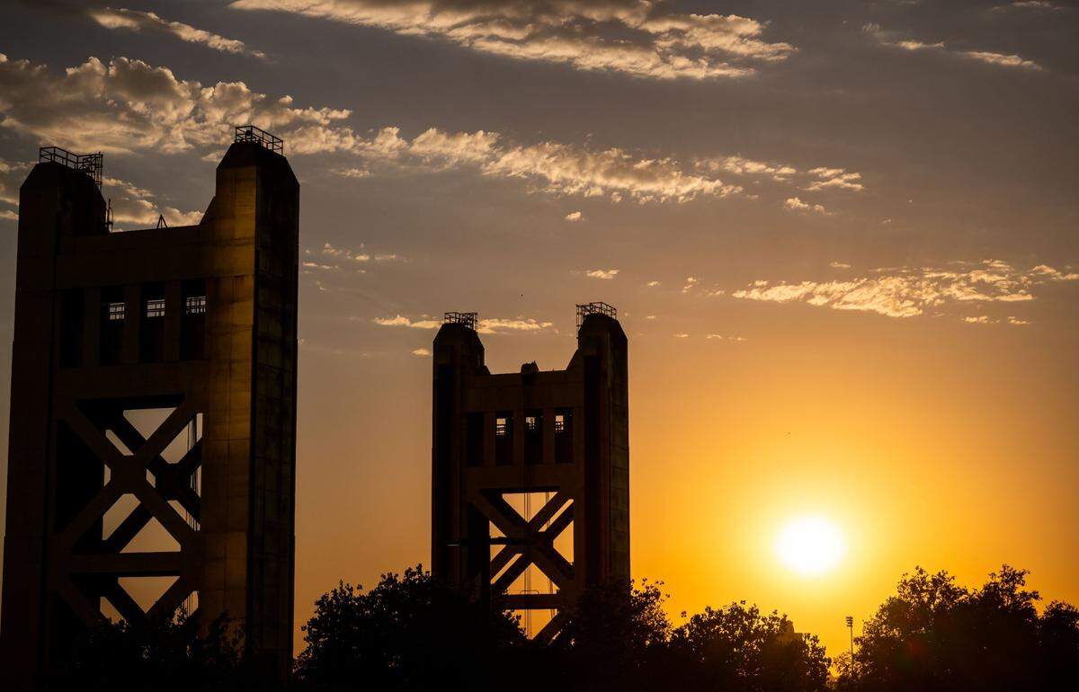The sun sinks lower in the sky past the Tower Bridge in Sacramento.