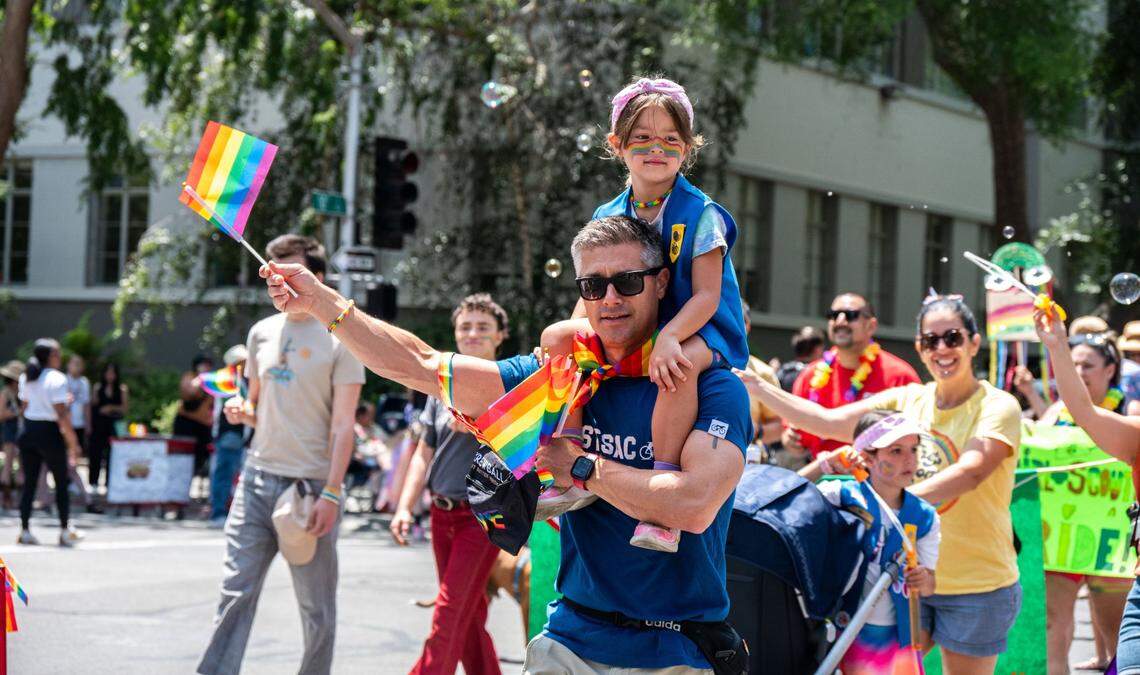 A father and his daughter march with the Girl Scouts at the Sacramento Pride March on June 15, 2025.