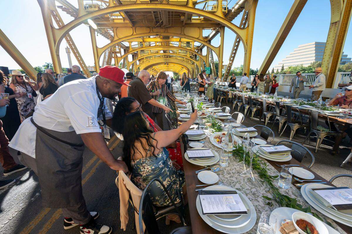 Chef Cecil Rhodes II of Nash & Proper takes for a photo with his wife Veronica Rhodes and her friend Darlene Osias at the Farm-to-Fork Festival’s Tower Bridge Dinner on Sunday.