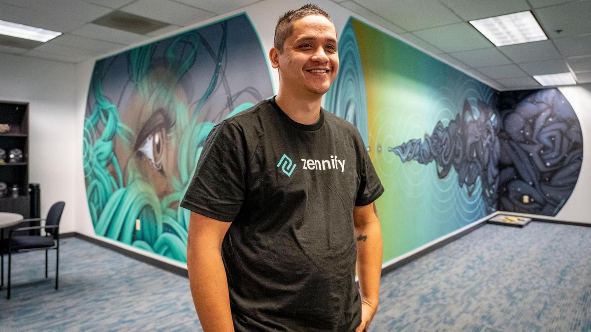 Rey Justo, of Sacramento, stands inside the offices of tech consulting firm Zennify in January. Laid off during the pandemic and after spending months living out of his car and with family, Justo started working at the company after graduating Sacramento’s digital upskilling program.